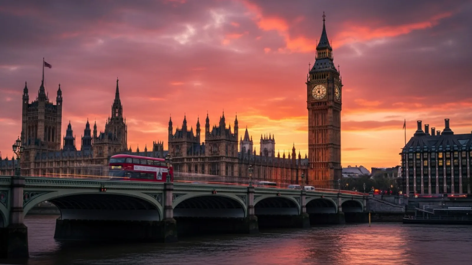 Big Ben and the Houses of Parliament at sunset with a red double-decker bus on Westminster Bridge